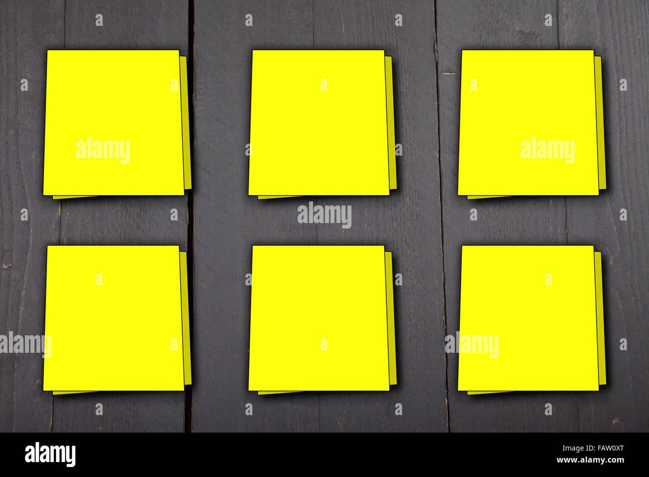 Six yellow memo notes on dark black wooden background Stock Photo