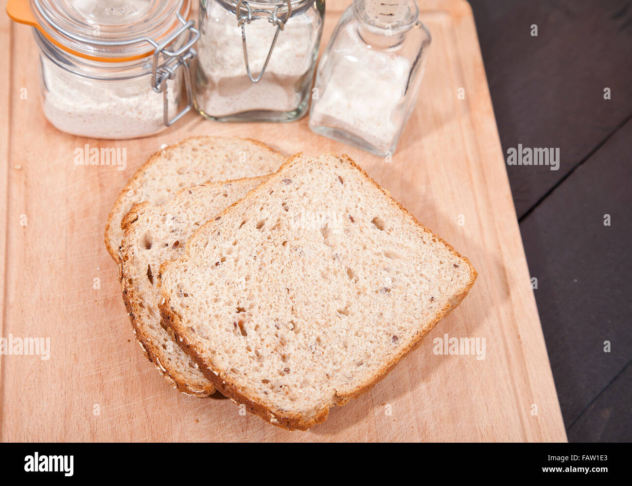 Gluten free bread on plate with spelled flower on black wooden background Stock Photo