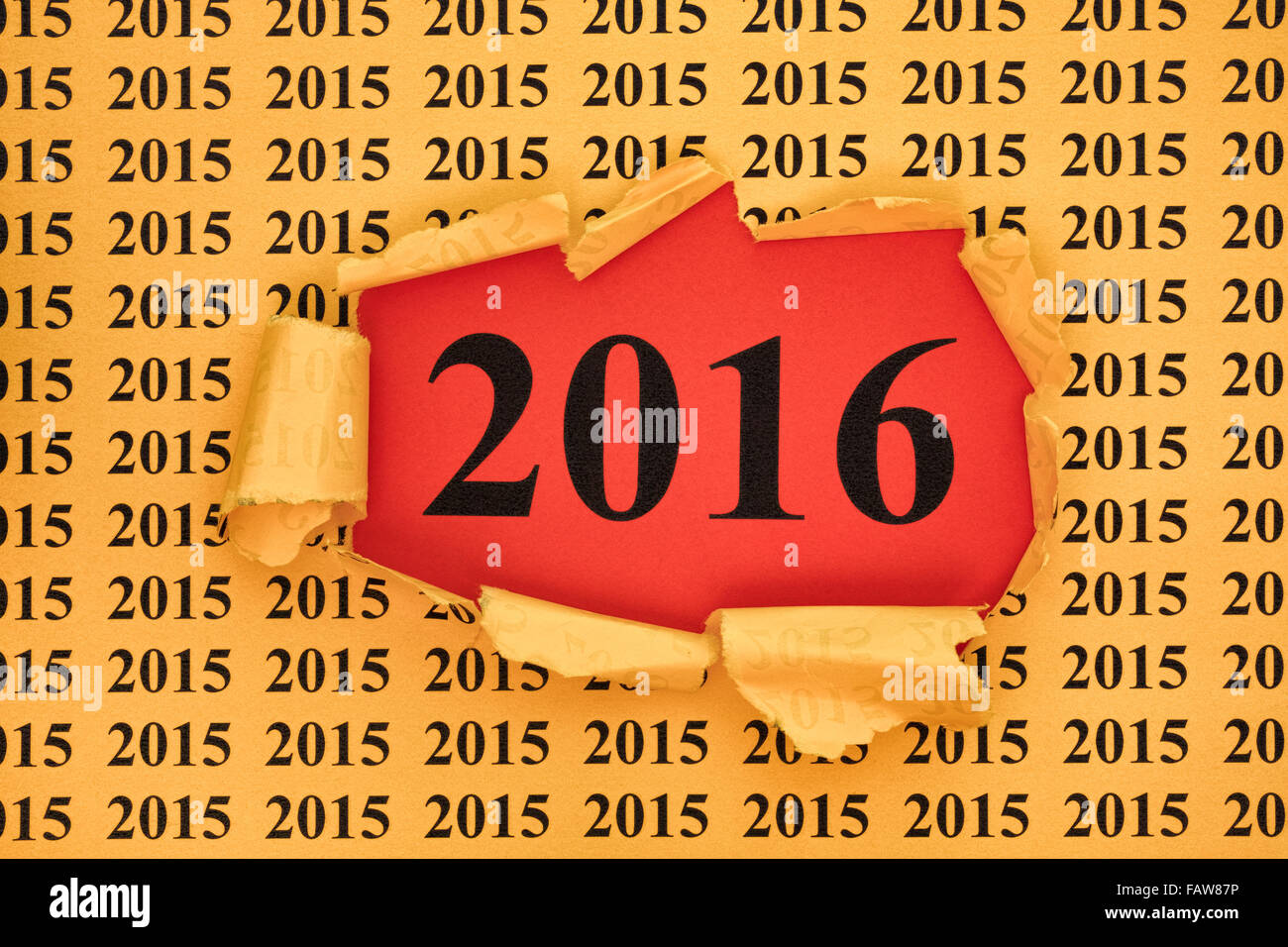 Year 2016 appears through the torn yellow paper with 2015 year ...