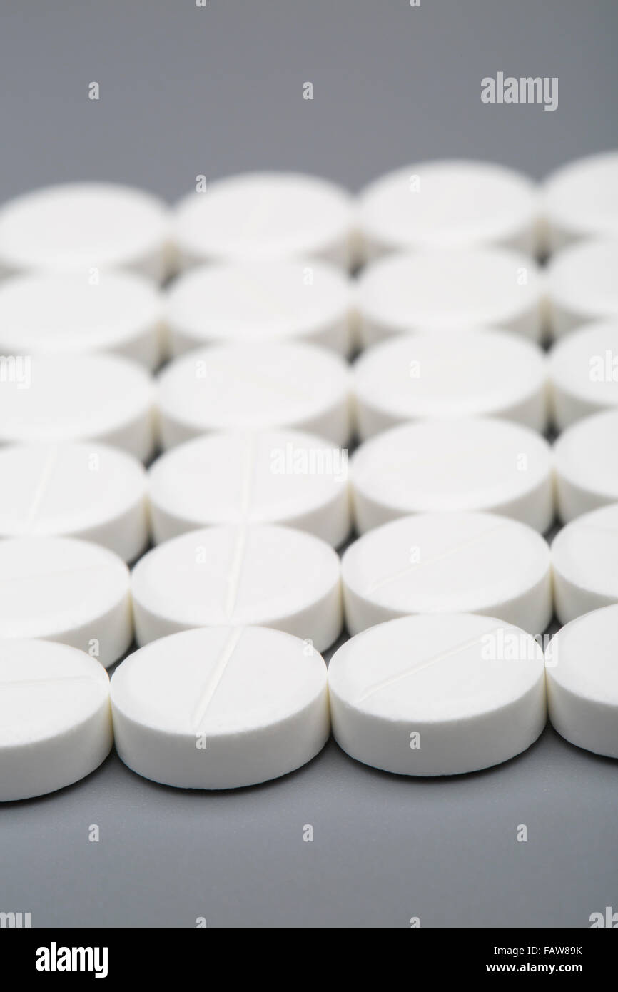 Round white pills on a gray background Stock Photo