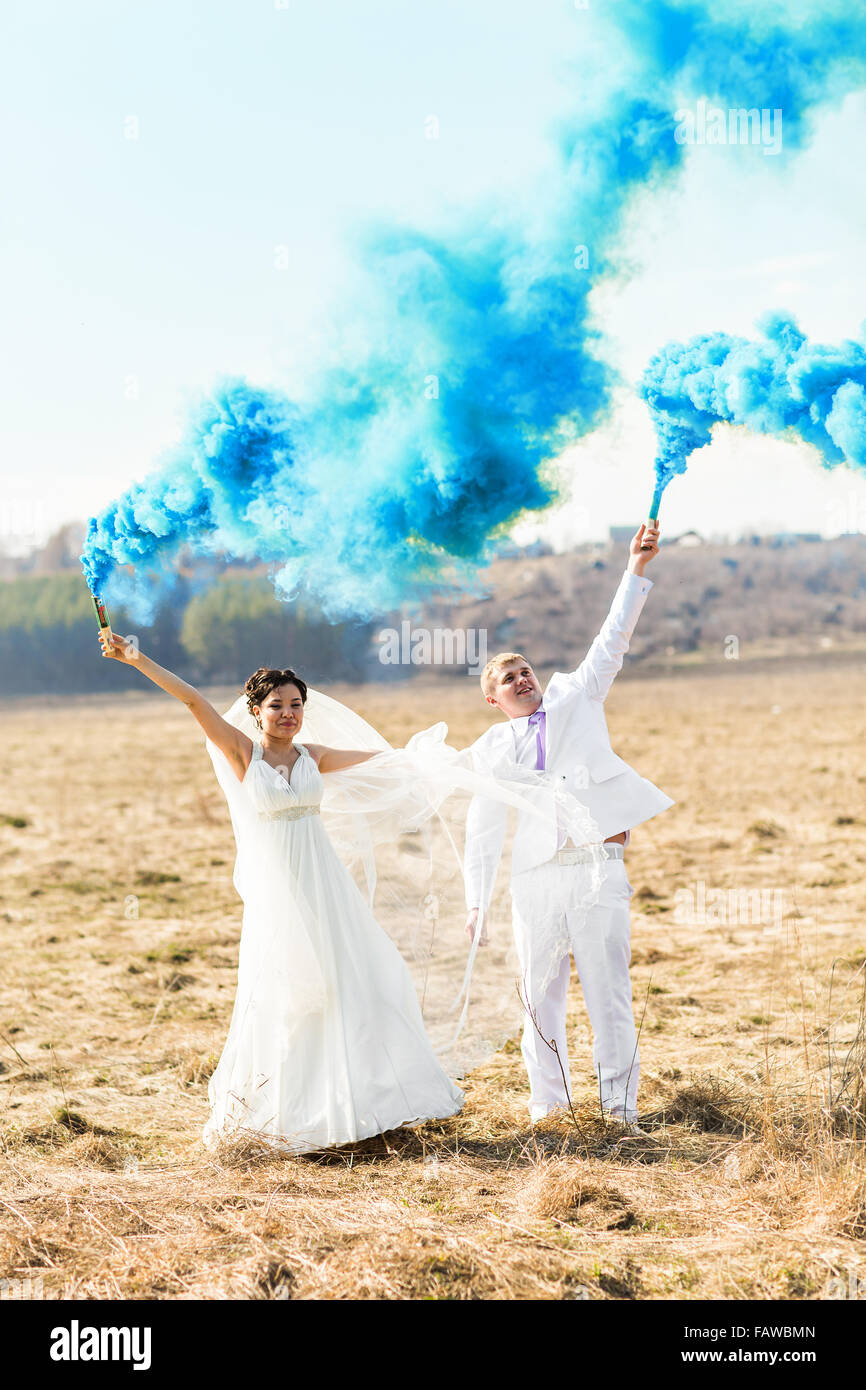 Wedding couple with blue smoke in the park Stock Photo - Alamy
