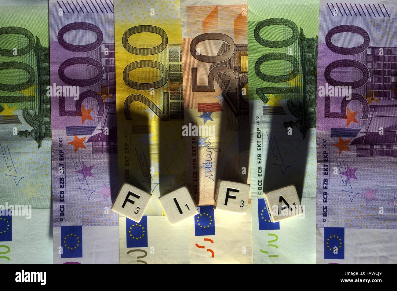 Berlin, Germany. 23rd Nov, 2015. Letter dices on Euro notes form the abbreviation of the International Federation of Association Football 'FIFA' and cast long shadows. The photo was taken in Berlin, Germany, 23 November 2015. - NO WIRE SERVICE - © dpa/Alamy Live News Stock Photo