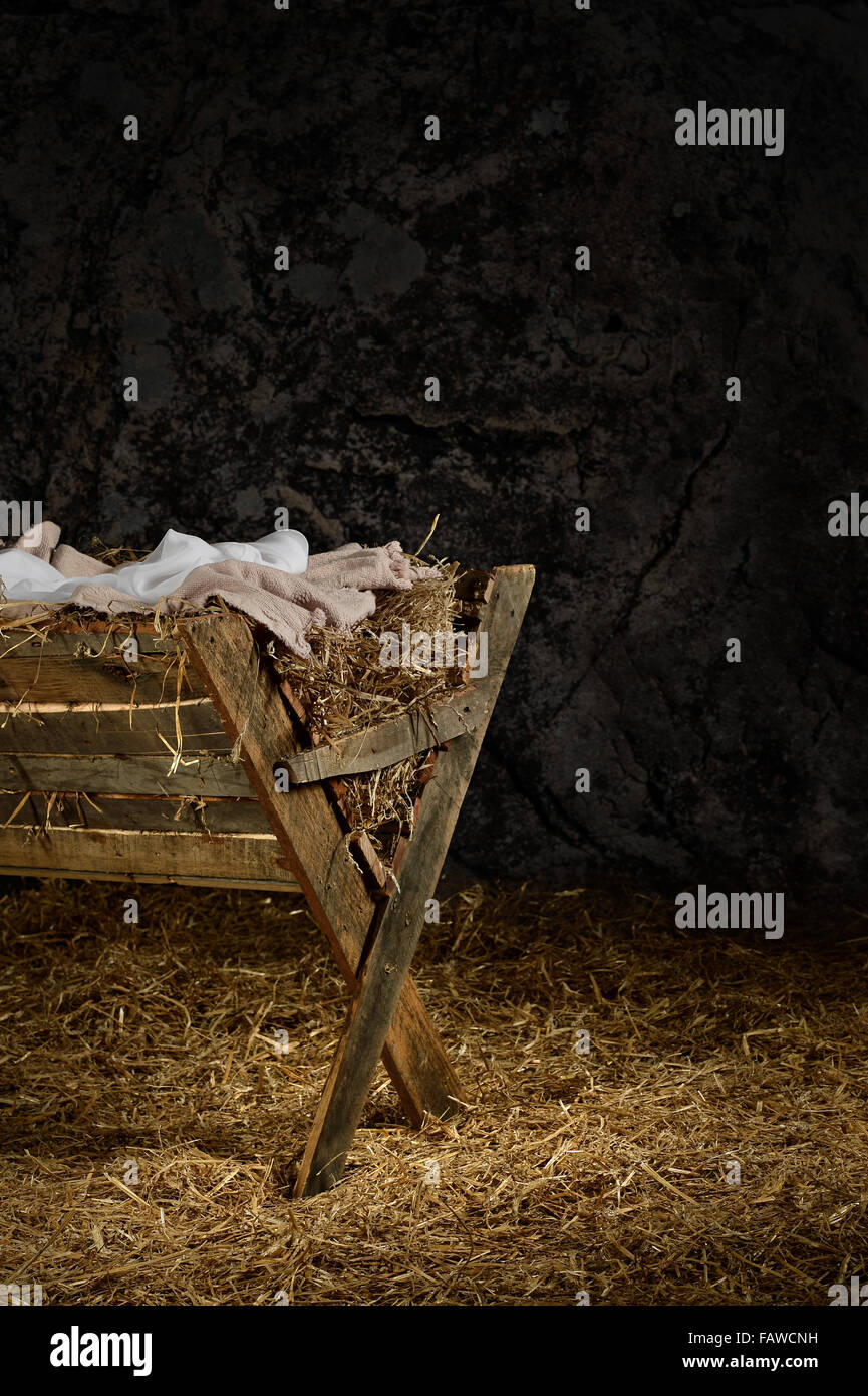 View of manger on straw covered floor in old barn Stock Photo