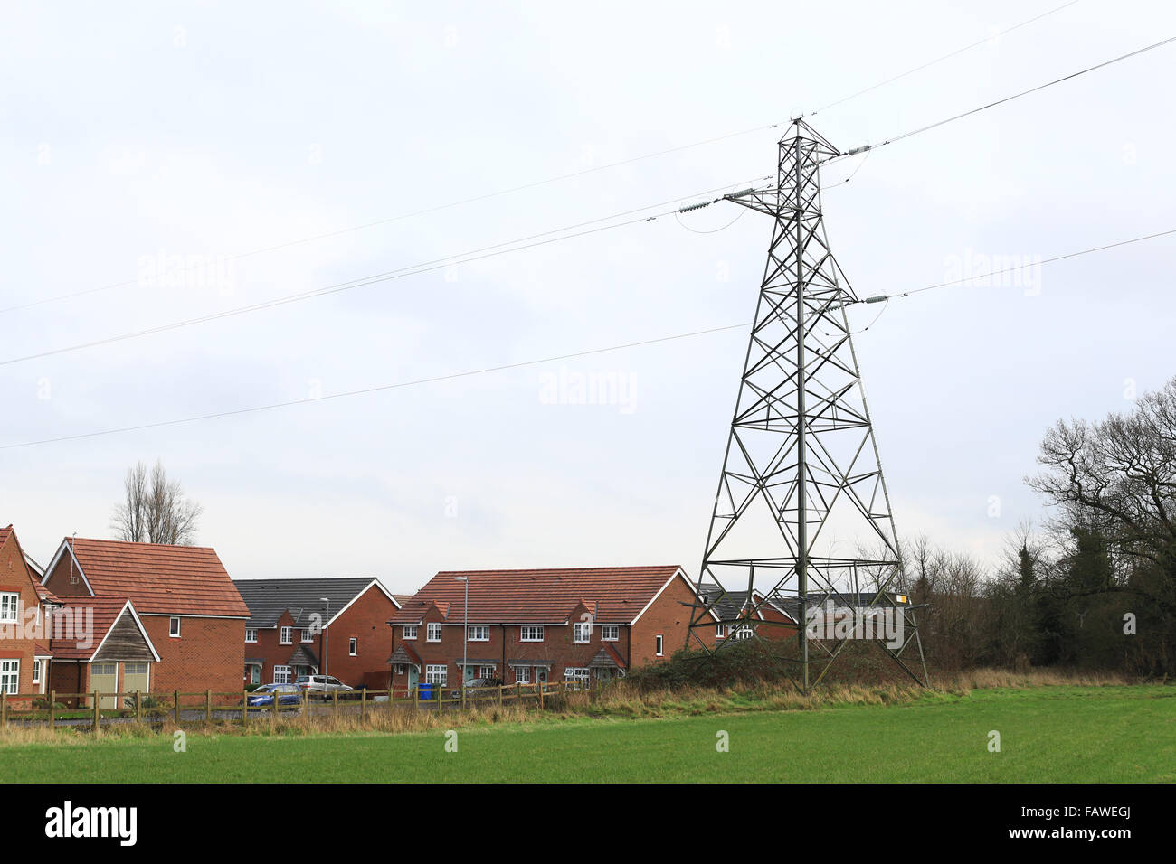 Electricity power lines and pylons over a new housing estate in Stafford, England Stock Photo