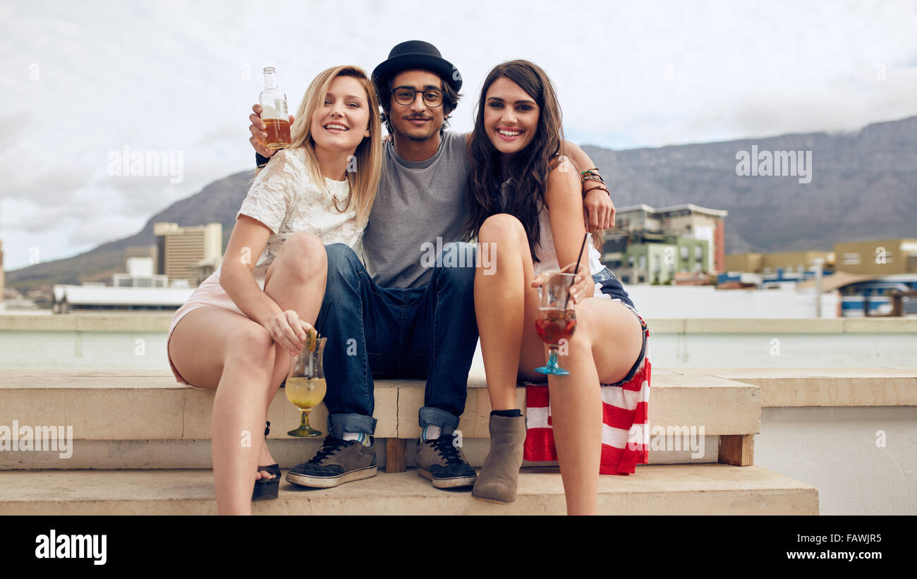 Portrait of best friends having a party on rooftop. Young man and women holding cocktails partying outdoors. Young people partyi Stock Photo