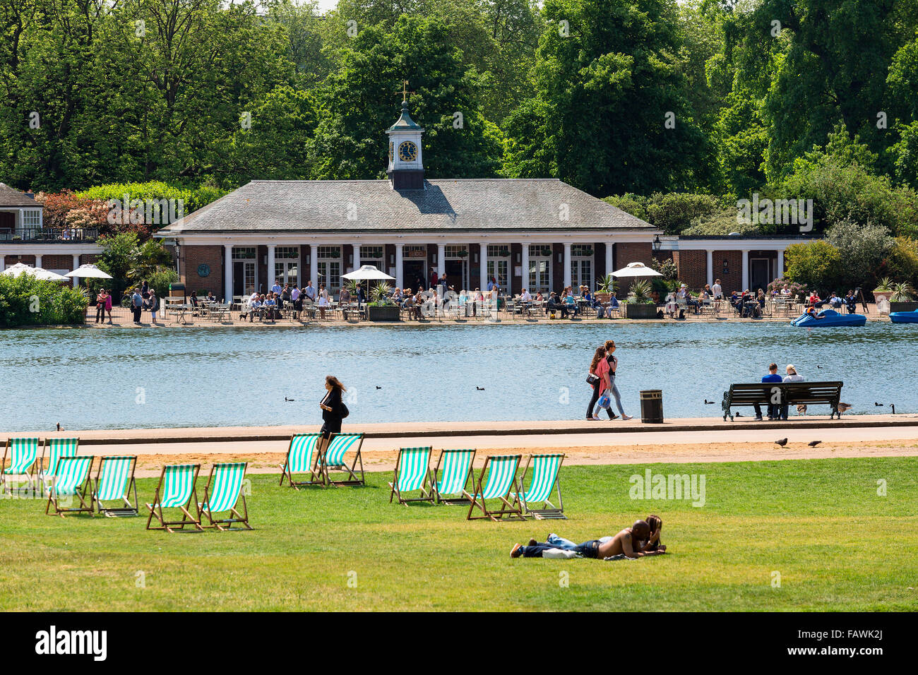 People in relaxing on lawns in deckchairs in Hyde Park in summer. Stock Photo