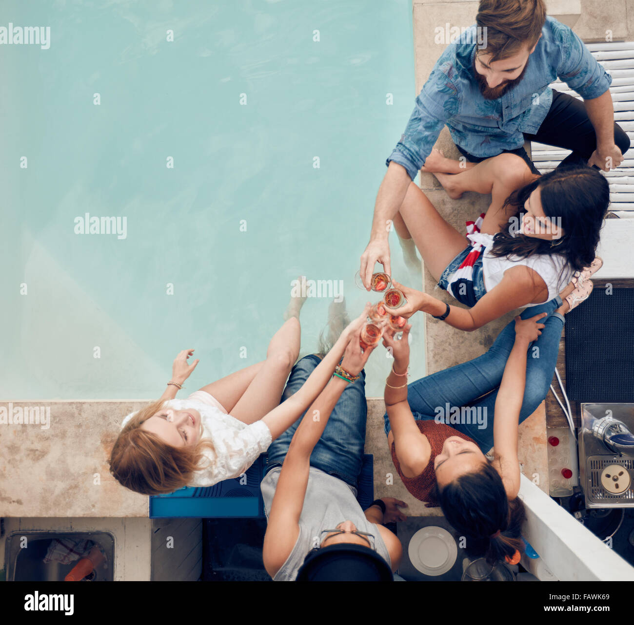 Top view of group of friends toasting at party by a swimming pool. High  angle shot of young people sitting by the pool having wi Stock Photo - Alamy