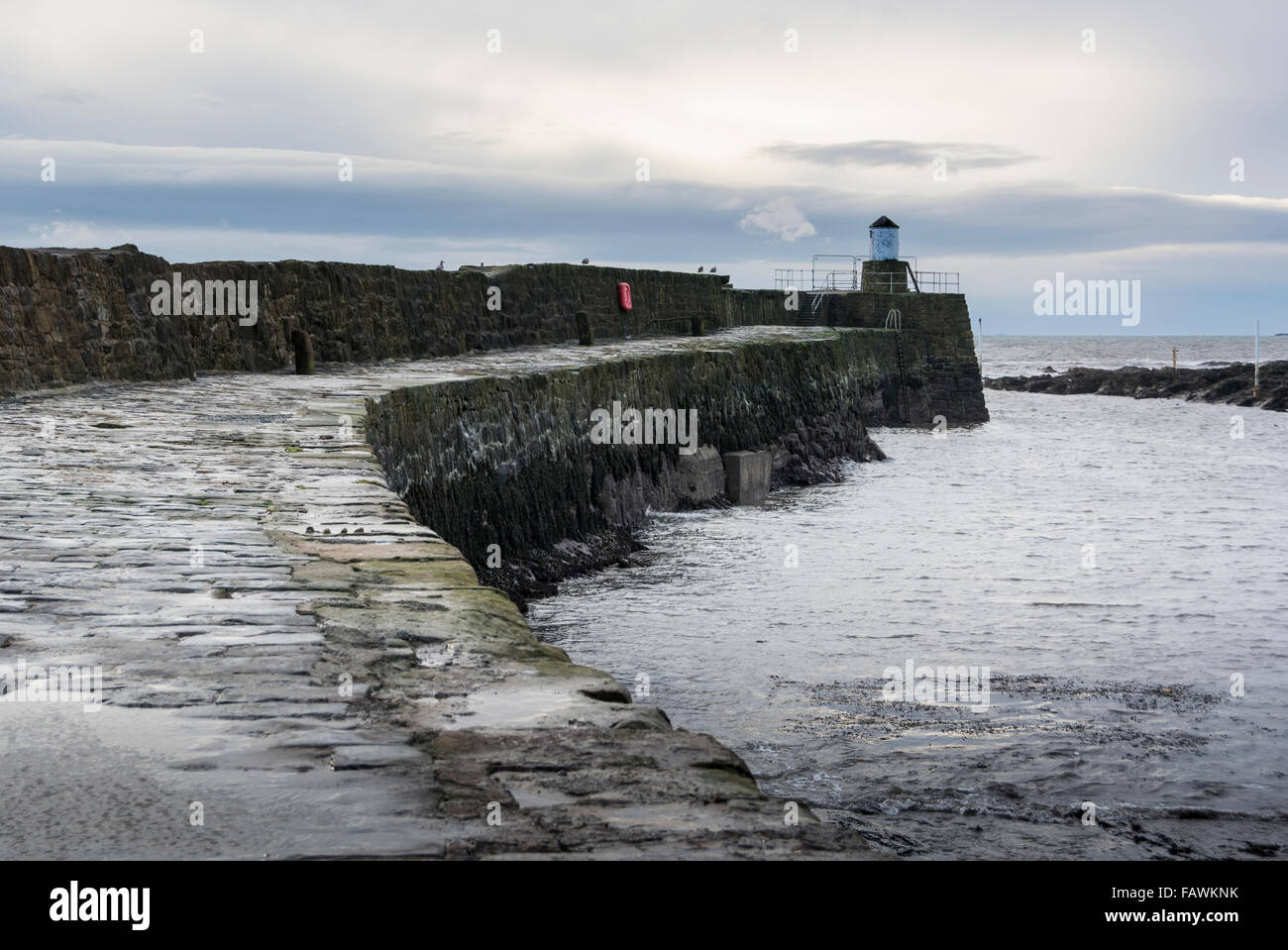 Harbour wall with lighthouse at the end in the pretty fishing village of Pittenweem on the coast of Fife, Scotland Stock Photo