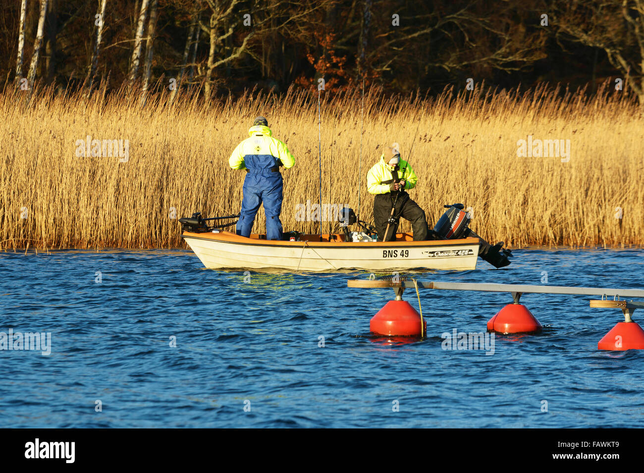 Ronneby, Sweden - December 30, 2015: Two persons fishing from a small open boat in late December. Sweden had very high average t Stock Photo