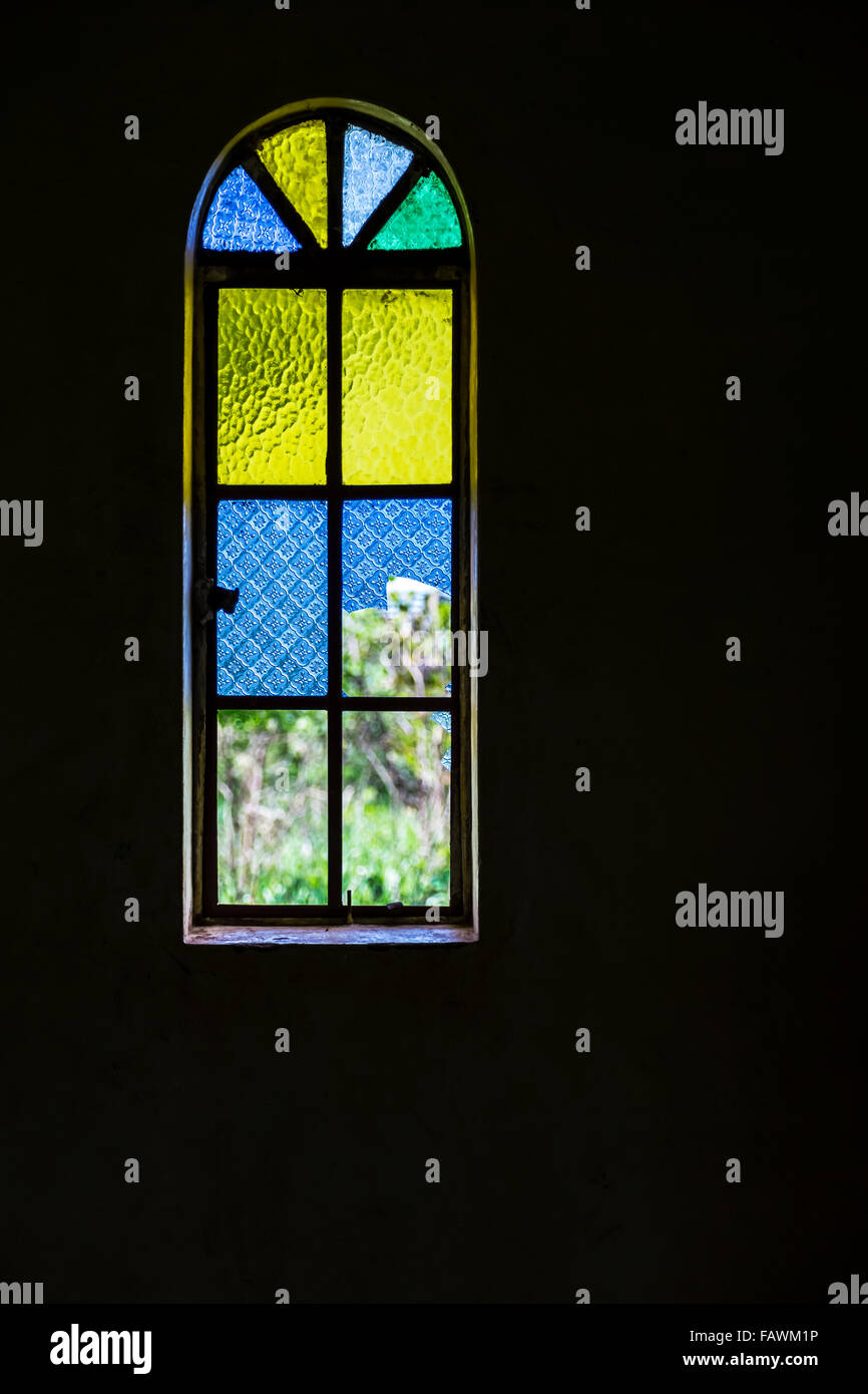 Blue, yellow and green stained glass window; Gulu, Uganda Stock Photo