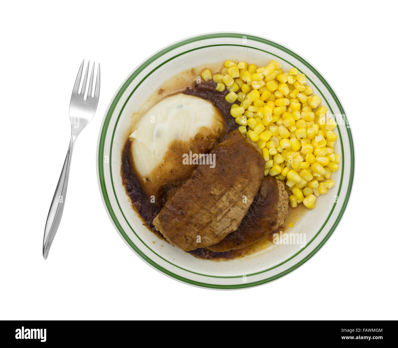 Top view of a microwaved meatloaf with gravy plus mashed potatoes and