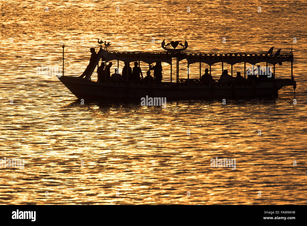 Silhouette of water taxi with tourists on the river Nile at sunset, Egypt Stock Photo