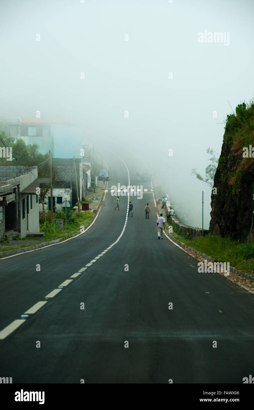 Asphalt road going down to fog and mist Stock Photo