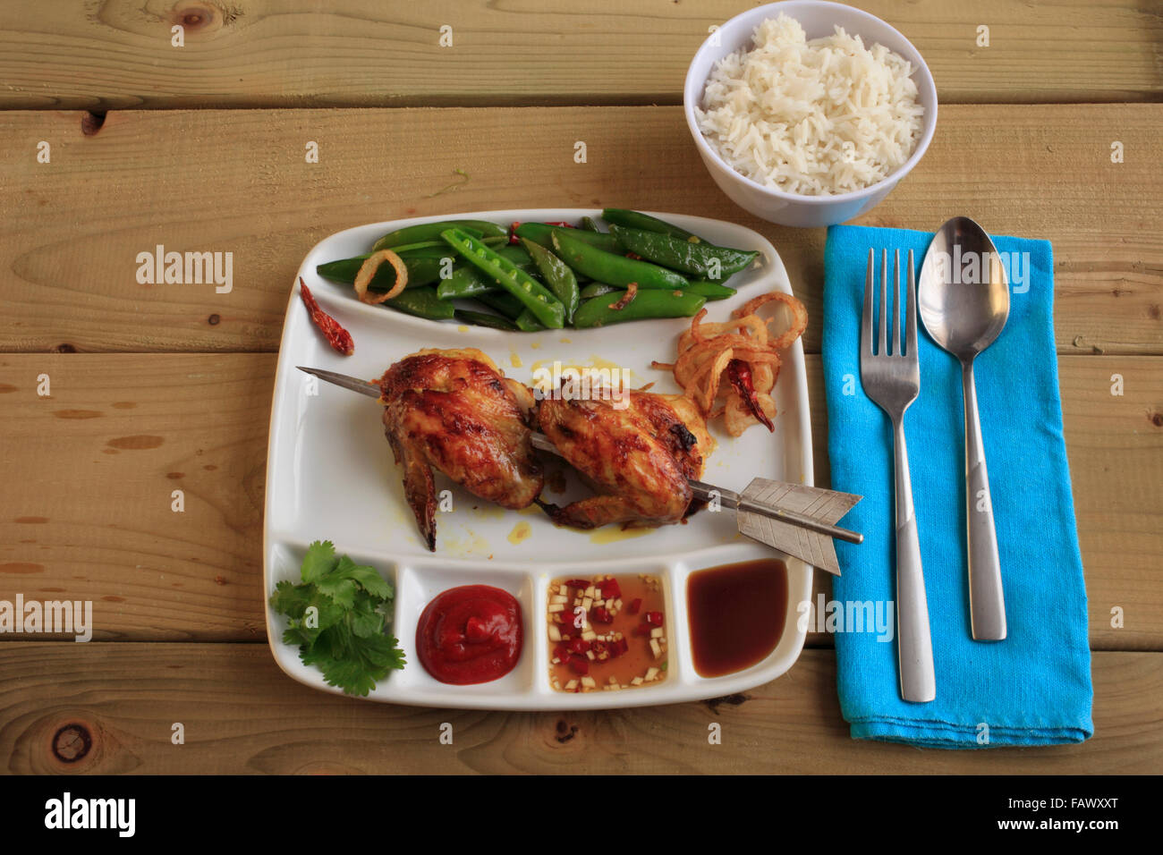 Thai-Lao Marinated Grilled Chicken with snap pea salad Stock Photo