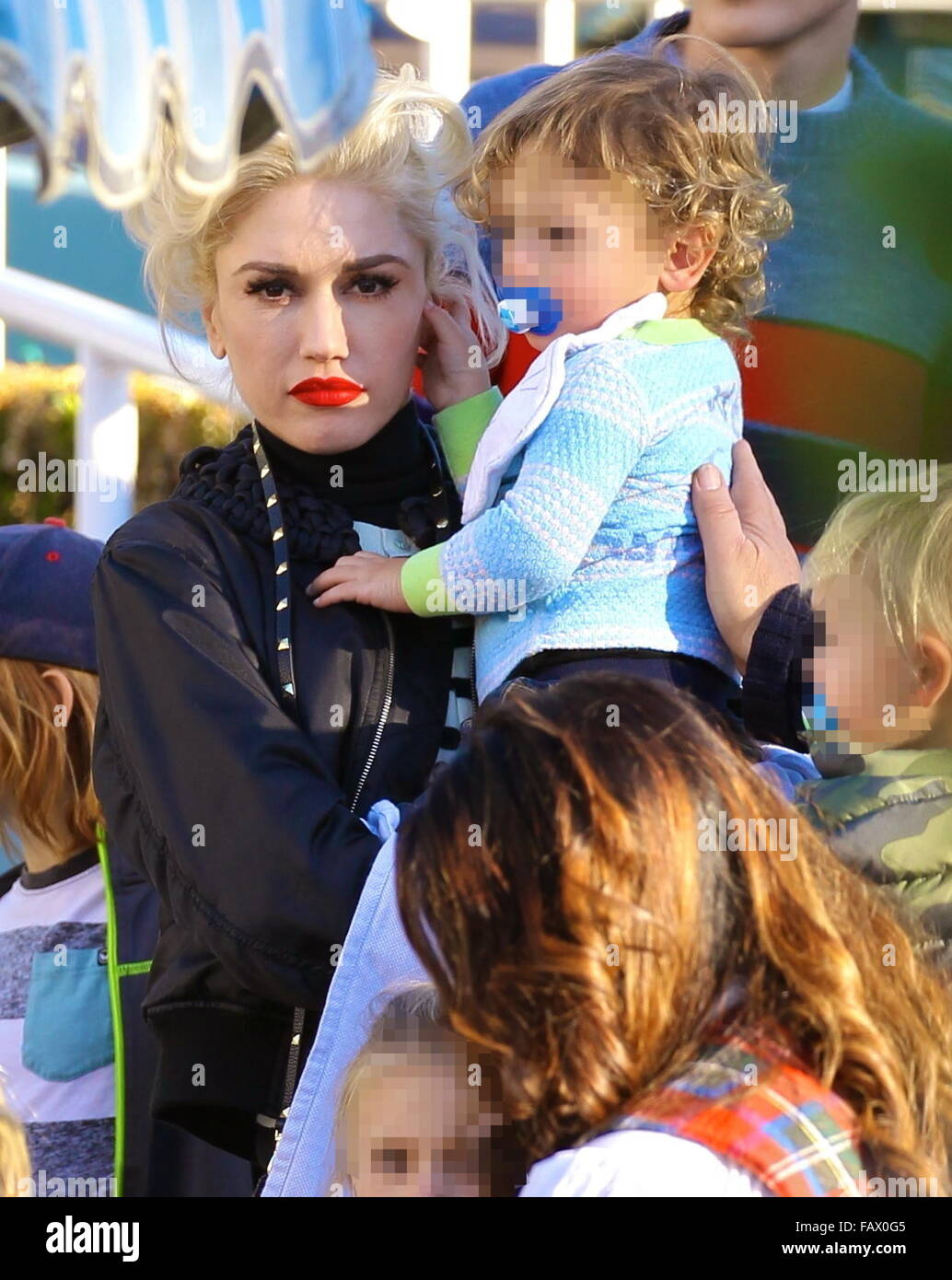 Gwen Stefani takes her three sons to Disneyland Park in Anaheim,  California. Gwen looked super glam, wearing a black moto jacket, with  skinny jeans and orange coloured Puma sneakers. She was seen