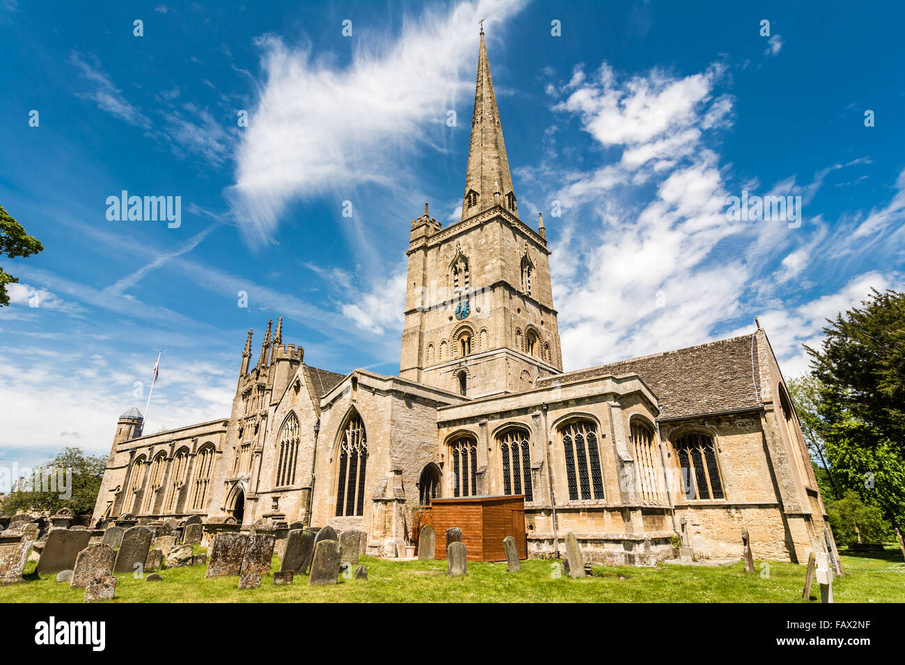 St John the Baptist church with old gravestones in the foreground, Burford, Oxfordshire, England, UK, Western Europe. Stock Photo