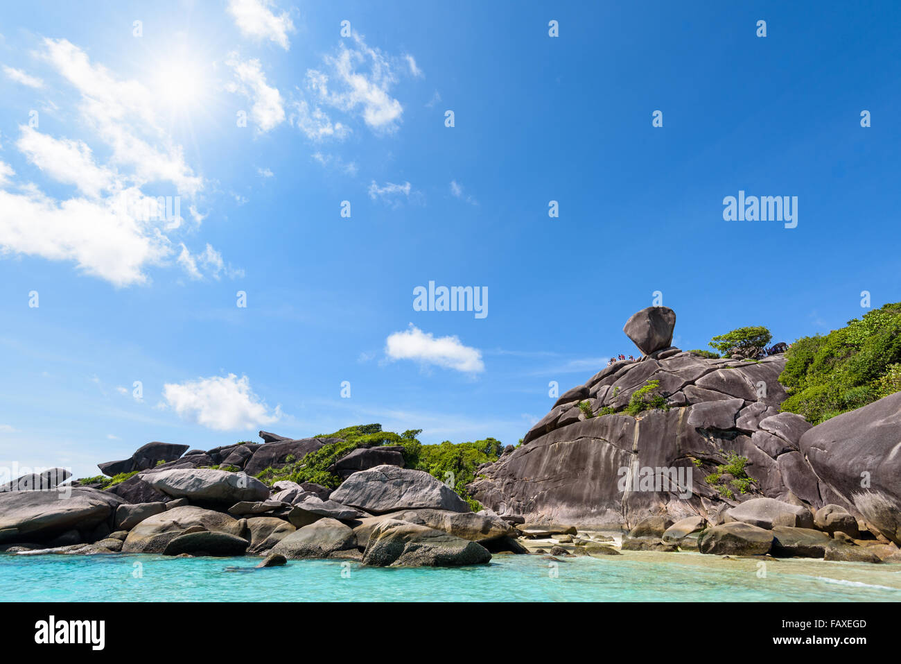 Beautiful landscape people on rock is a symbol of Similan Islands, sun on blue sky over the sea during summer at Mu Ko Similan Stock Photo