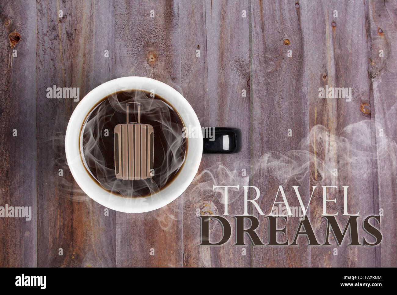 Dreaming of travel over hot cup of coffee concept - mug placed on wooden table with hot black coffee and suitcase Stock Photo