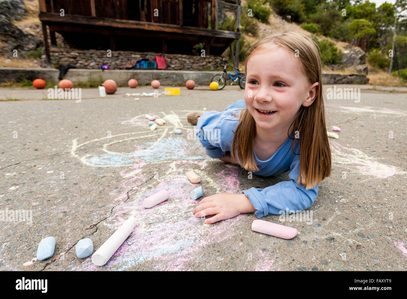 Young girl drawing with sidewalk chalk Stock Photo - Alamy