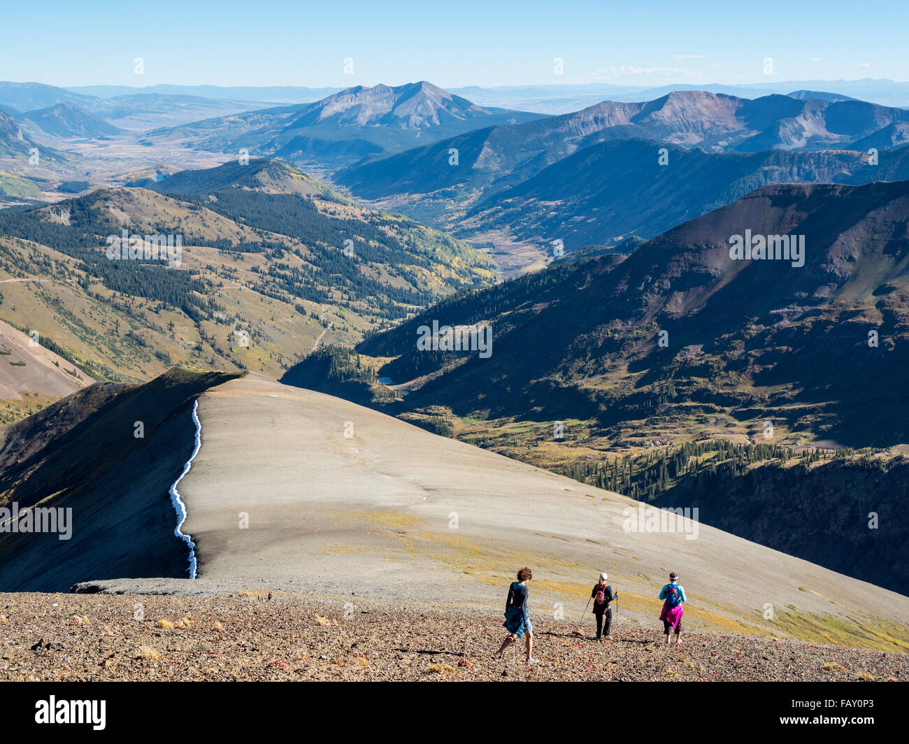 CRESTED BUTTE, COLORADO - SEPTEMBER 20, 2015: Hikers traverse high elevation alpine terrain, Ruby Range, Elk Mountains Stock Photo