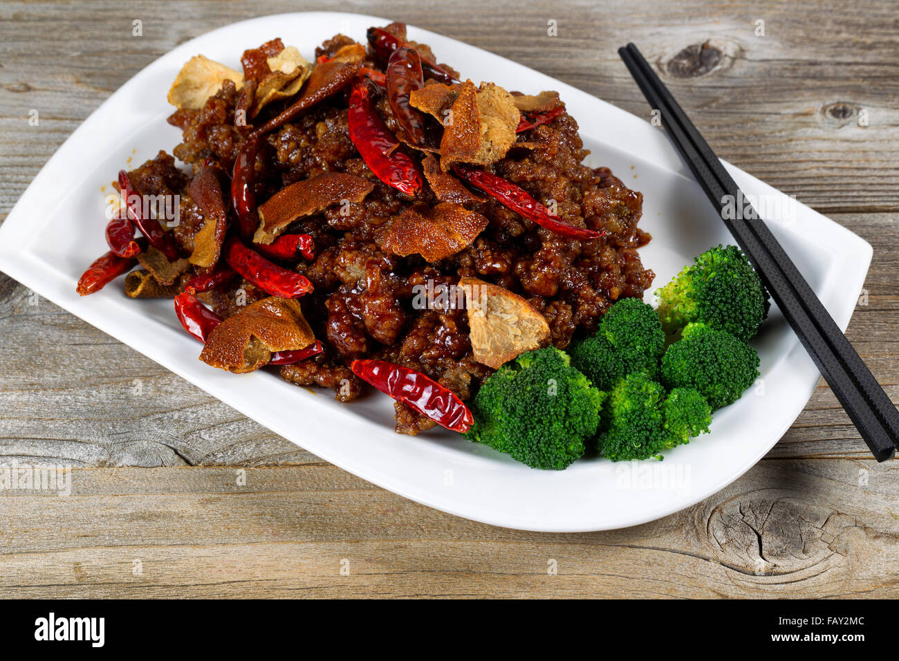 Close up front view of Chinese dish consisting of fried tofu, chicken, red peppers, and broccoli. Stock Photo