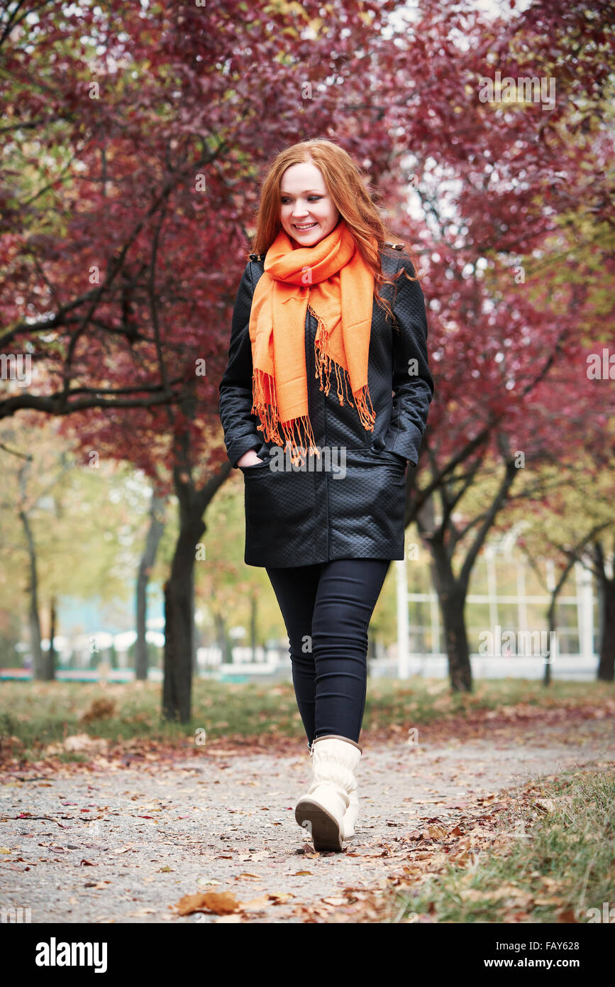 redhead girl walk on pathway in city park, fall season Stock Photo Alamy