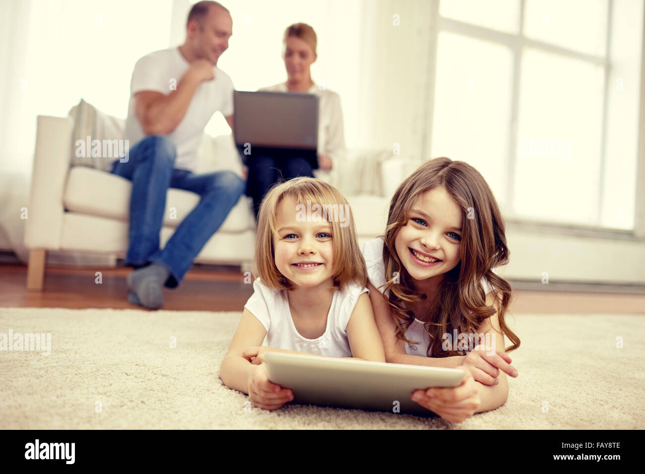 happy little girls with tablet pc computer at home Stock Photo - Alamy