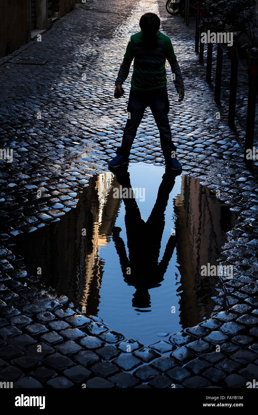 Kid mirroring in a puddle Stock Photo