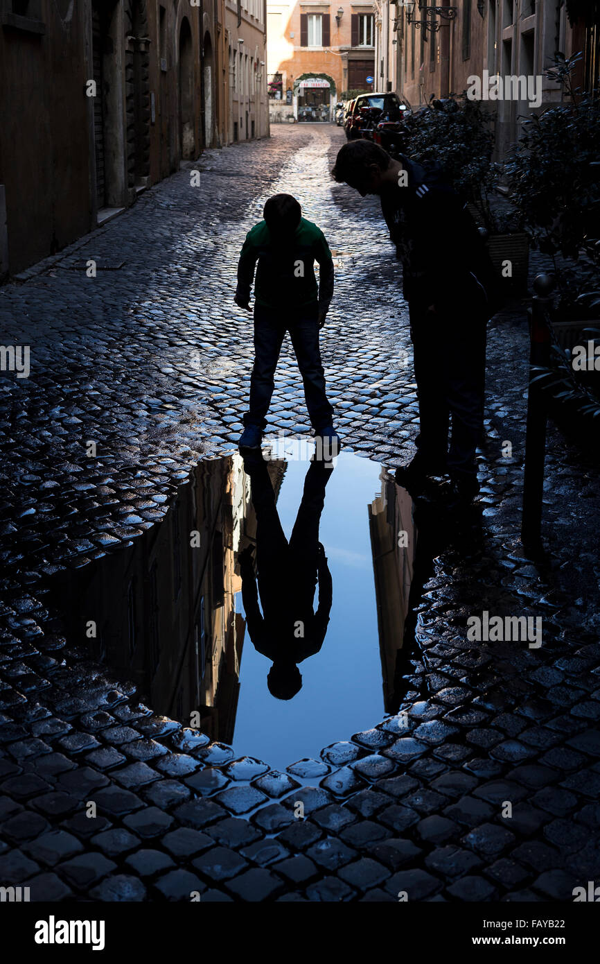Kid mirroring in a puddle Stock Photo