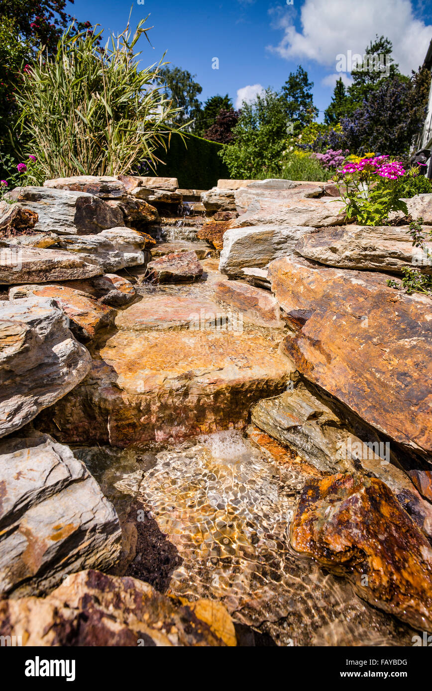 A new waterfall and rockery in a rural garden Stock Photo