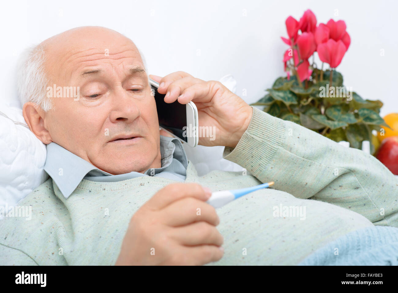 Despondent weary aged man calls up his relatives. Stock Photo