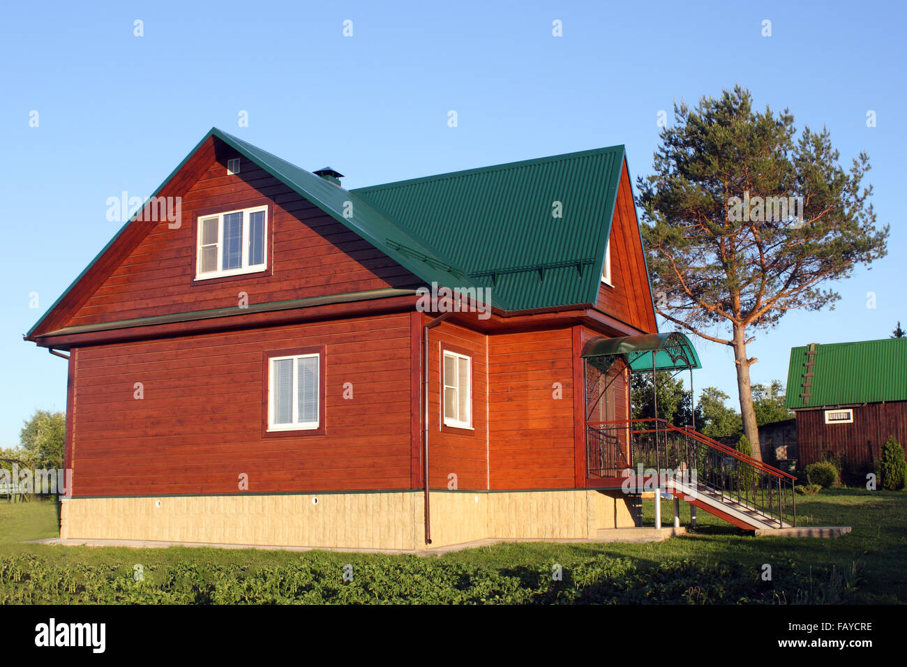 Wooden house under green metal roof photo Stock Photo