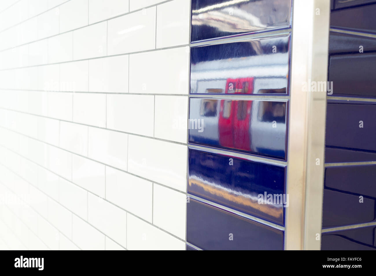 A new S-Stock tube reflection is seen on tiles at Sloane Square station. Stock Photo
