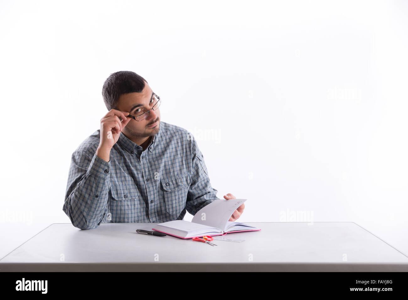 Young teacher with glasses holds notebook on a white desk Stock Photo ...