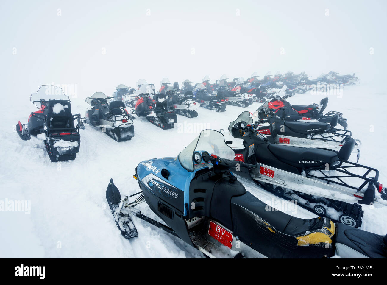 Snowmobiles lined up, snowy day, Iceland Stock Photo