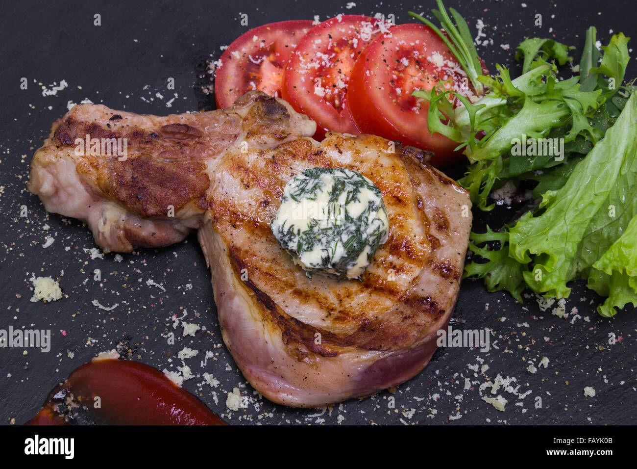 Grilled pork chop with vegetables and tomato sauce Stock Photo