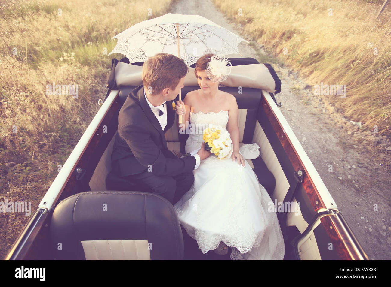 Bride and groom in a vintage car Stock Photo - Alamy