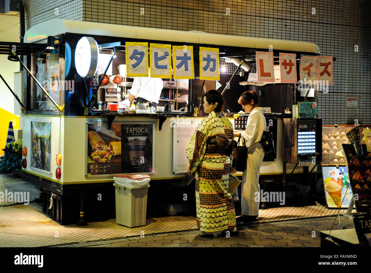 Two Japanese women buying street food wearing kimono in Asakusa Tokyo Japan Stock Photo