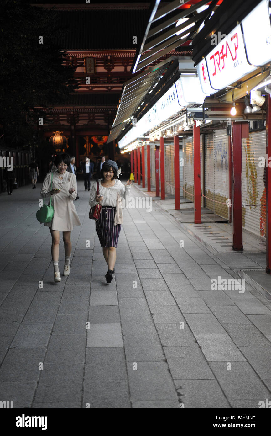 Two Japanese girls walking in a street of Asakusa district Tokyo Japan Stock Photo