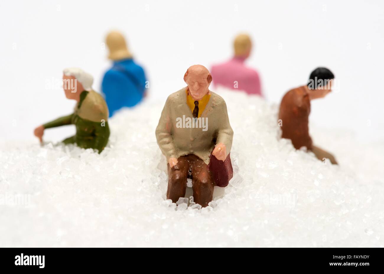 Miniature people sitting on a pile of white sugar diabetes concept Stock Photo