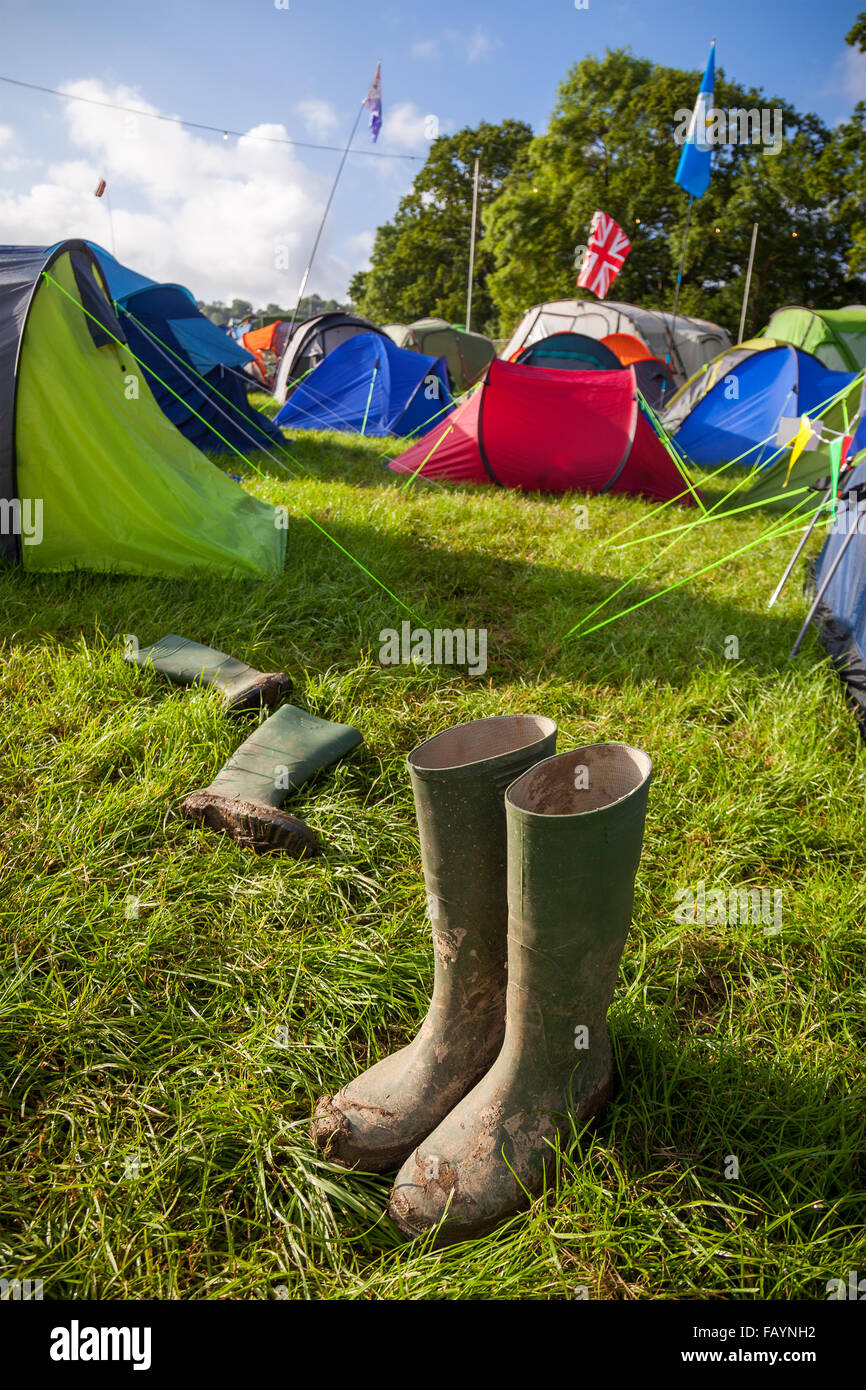 A pair of muddy wellington boots at a British music festival campsite. Shallow depth of field with selective focus on the boots. Stock Photo