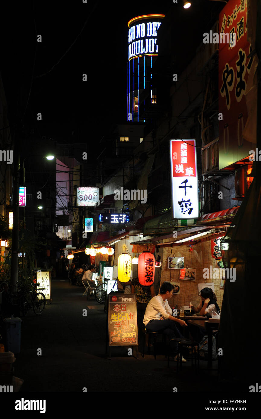 man and woman eating in a yakitori restaurant in Shinjuku Tokyo Stock Photo