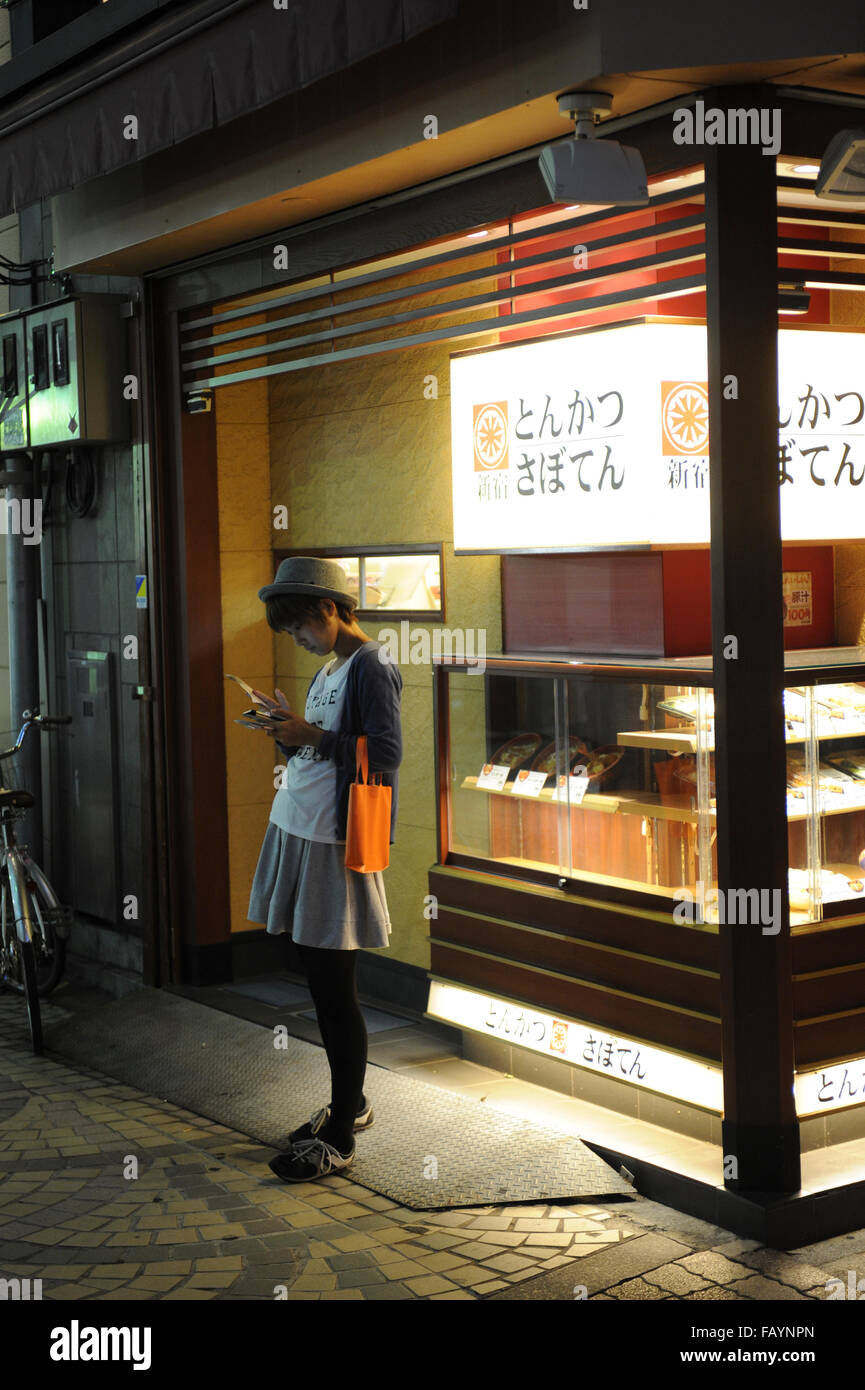 Japanese girl looking at the smart phone in Asakusa Tokyo Japan Stock Photo