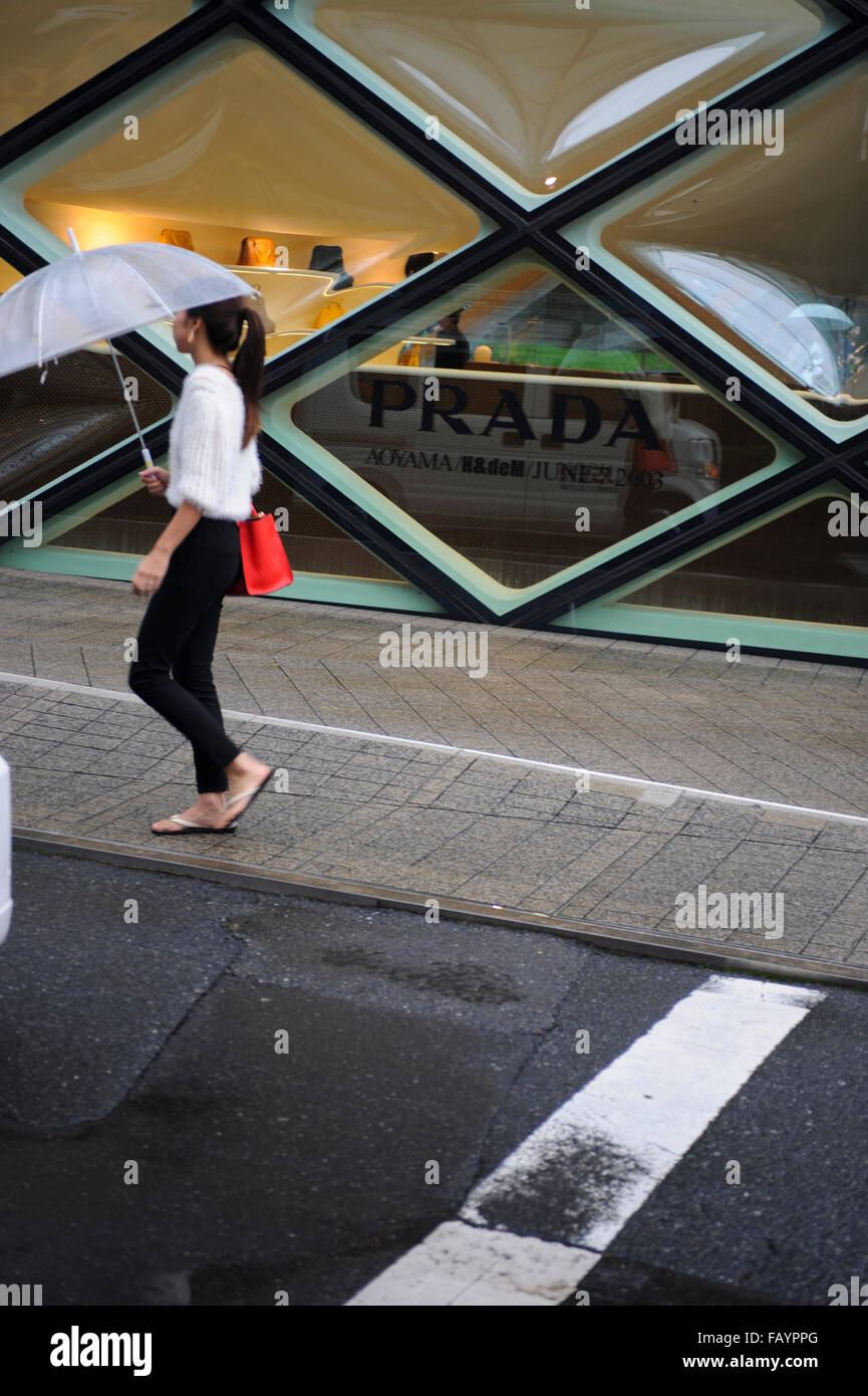 Woman walking in front of the Prada store in Omotesando Tokyo Japan Stock Photo