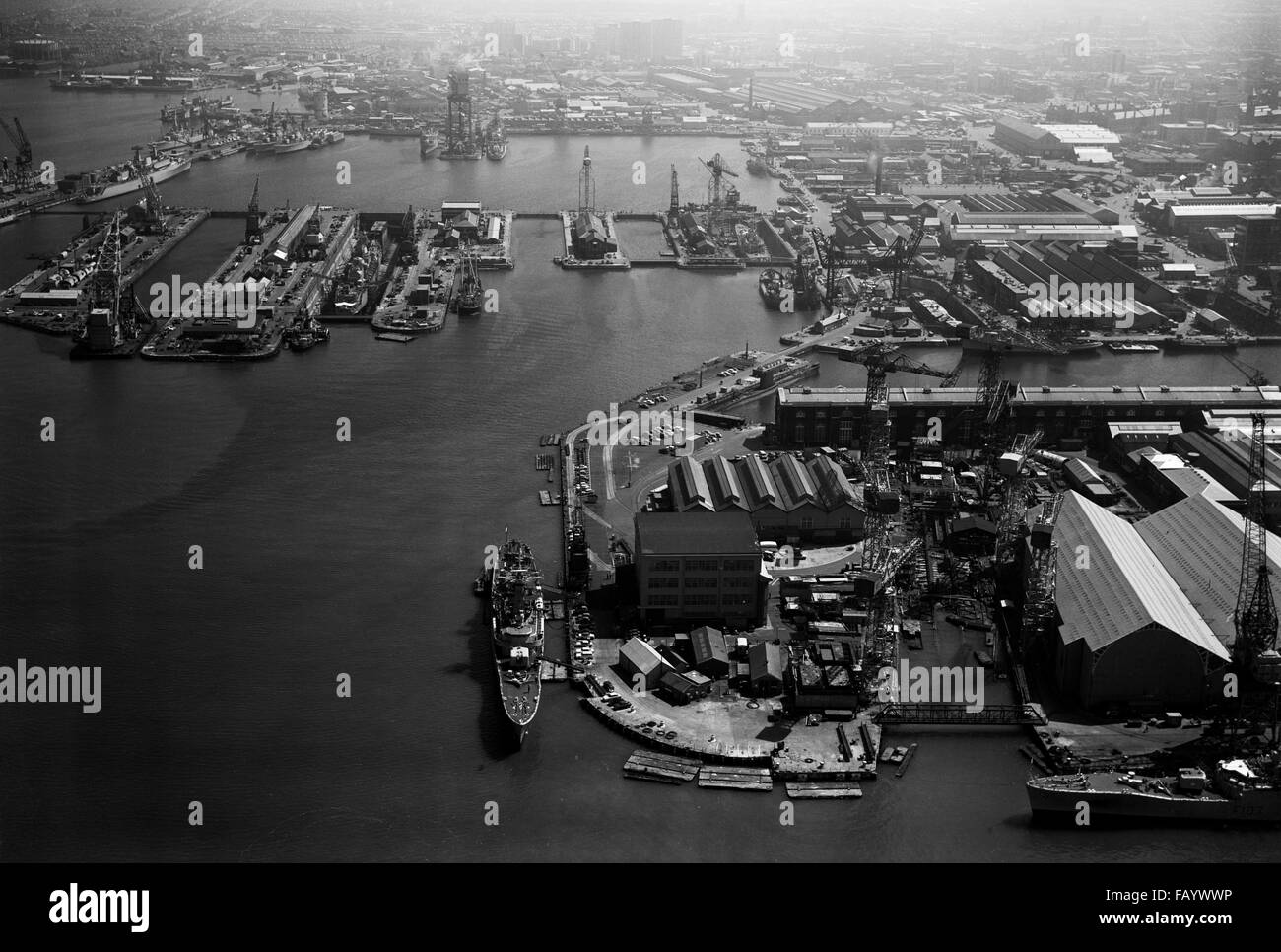 AJAXNETPHOTO - 1970S - PORTSMOUTH, ENGLAND. - NAVAL BASE AERIAL - AN AERIAL VIEW OF THE NORTH SECTOR OF THE NAVAL BASE SHOWING (DISTANT, TOP LEFT.) FLATHOUSE QUAY AND NORTH WALL JETTY, HAMMERHEAD CRANE (TOP,LEFT CENTRE.), BASIN AND DRY DOCKS (MIDDLE.) AND NORTH WEST CORNER WITH HMS CHARYBIDIS MOORED (FORE&AFT,BOTTOM,CENTRE.). HMS ROTHESAY (F107) MOORED BOTTOM RIGHT.   PHOTO:VT COLLECTION/AJXNETPHOTO REF:VT5 NB70 AVLVT5C VTCOLL 00001 Stock Photo