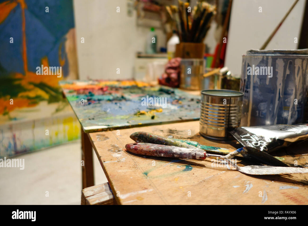 Two palette knifes in an artist studio with paint and painters table. Stock Photo