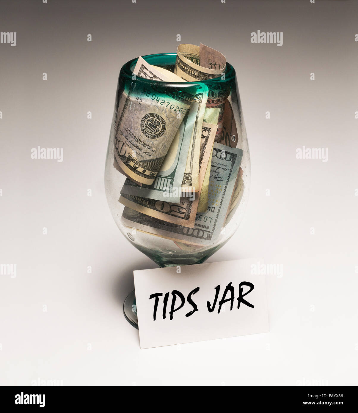 50 bills and 100 bills in tips jar with sign Stock Photo Alamy