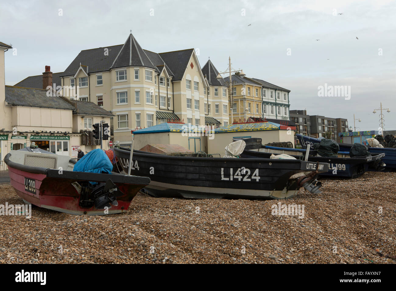 Fishing boats lined up on the beach at Bognor Regis. Seafront properties and hotels in the background. Stock Photo