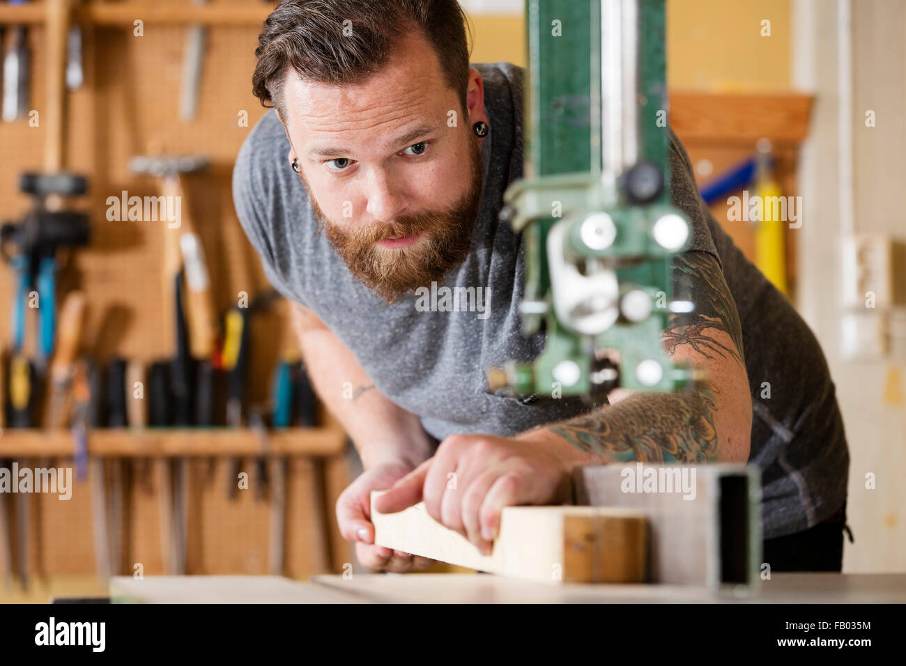 Craftsman using bandsaw for splitting wood plank in workshop Stock ...