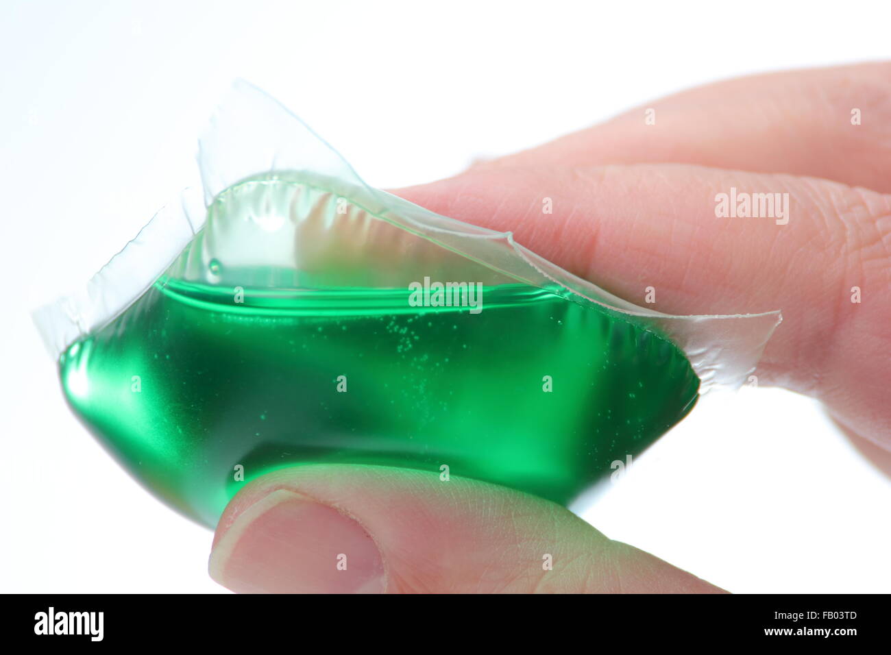 A liquid laundry detergent capsule held by a man, UK. Stock Photo